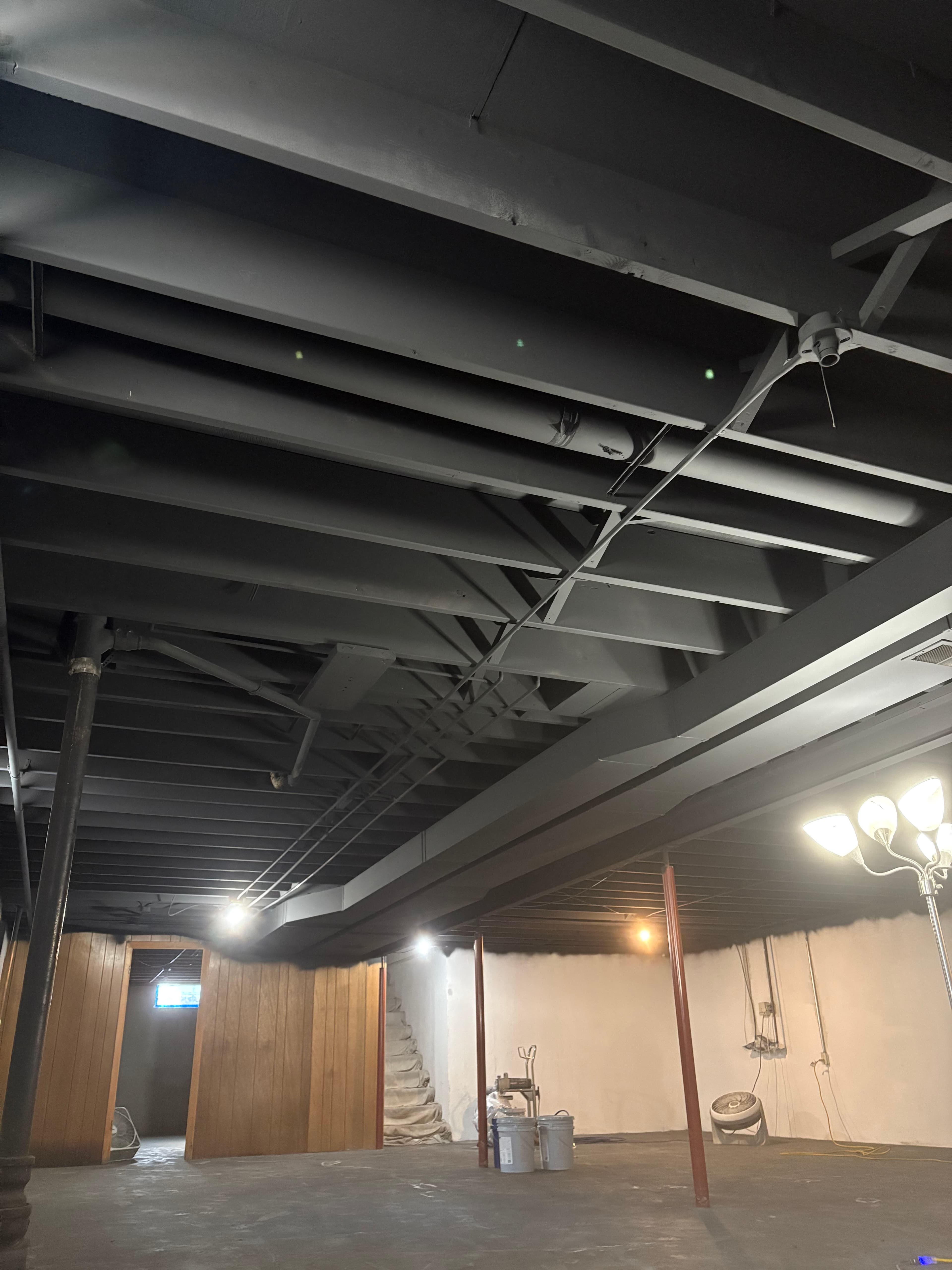 Exposed basement ceiling completed with a black painted finish